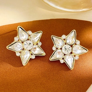 Detailed view of gold-plated star earrings with sparkling cubic zirconia crystals