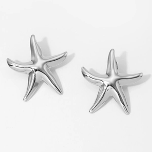 Macro shot of polished silver starfish earrings with smooth stainless steel texture