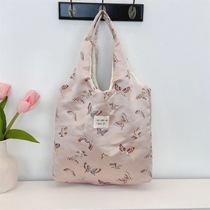 Detailed shot of pink jacquard butterfly pattern and woven label on a canvas shoulder bag