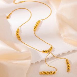 Minimalist gold titanium necklace featuring multiple polished oval beads on a fine chain