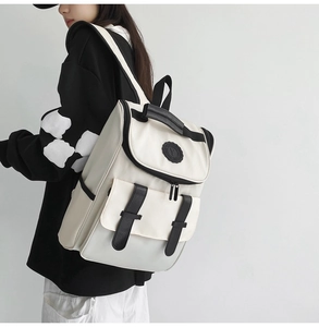 Rear view of model wearing a stylish off-white backpack with black strap accents
