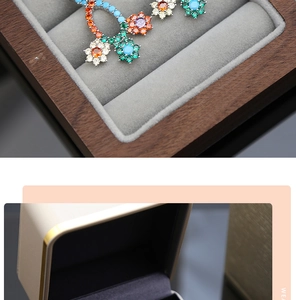 Detailed macro view of colorful floral zircon earrings inside a premium wooden jewelry box