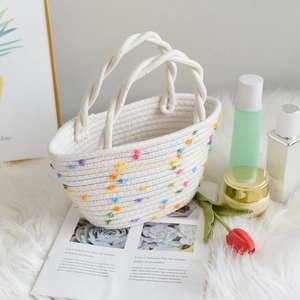 Detail einer handgewebten Baumwolltasche mit bunten Bommeln und Regenbogenstich