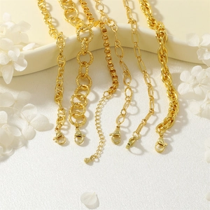 Dettaglio di cinque stili di bracciali a catena dorati con diverse maglie strutturate