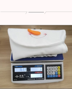 Weight display of snowman toilet lid cover at 163.3g on a scale for product specification