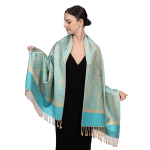 Dettaglio di scialle paisley di lusso color verde acqua e oro con frange e jacquard