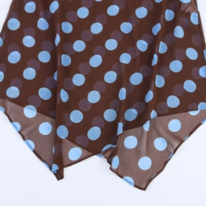 Detailed view of lightweight brown mesh fabric with blue and purple polka dot pattern