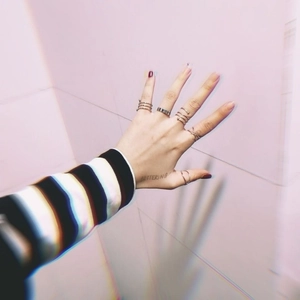 Close-up of hip-hop style metal rings stacked on fingers with a minimalist aesthetic