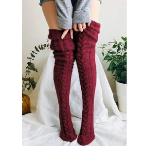 Detail of burgundy cable-knit over-the-knee leg warmers with thick ribbed texture