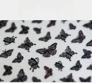 Macro detail of 5D embossed blood butterfly nail stickers with pearlescent wing texture
