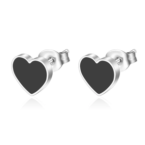 Macro shot of minimalist black heart stud earrings with silver edges and metal butterfly back