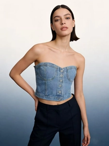 Détail du haut bustier en jean bleu clair avec boutons en métal et surpiqûres
