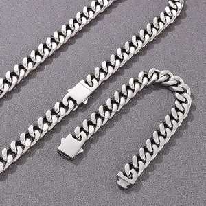 Détail de l'ensemble collier et bracelet à maille gourmette en acier argenté avec fermoir