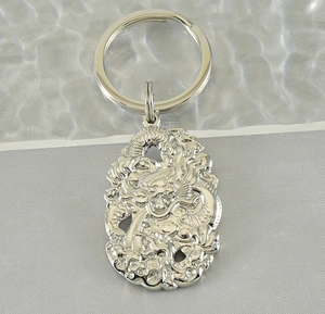 Macro detail of silver stainless steel Chinese dragon keychain with embossed relief