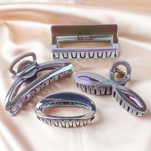 Set of four iridescent mermaid hair claws in assorted shapes on soft peach satin fabric