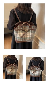 Detail view of the vintage plaid wool and brown leather texture on a large bucket backpack