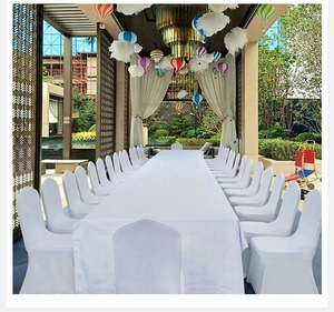 White elastic chair covers and long tablecloths arranged for a formal banquet event