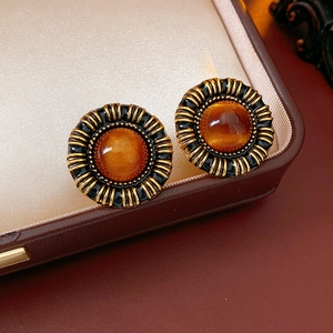 Detail of vintage resin heart stud earrings in antique gold on a premium jewelry box