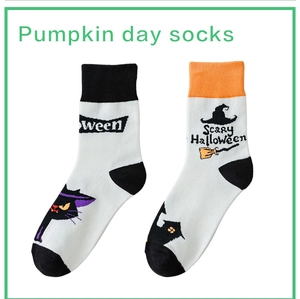 Detail of Halloween socks with black cat, witch hat, and Scary Halloween text patterns