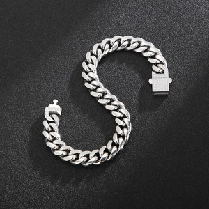 Close-up of a polished silver Cuban link bracelet with micro-pave diamond accents