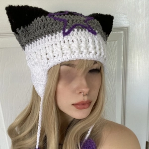 Close-up of handmade crochet cat ear hat with tricolor stripes and purple star embroidery