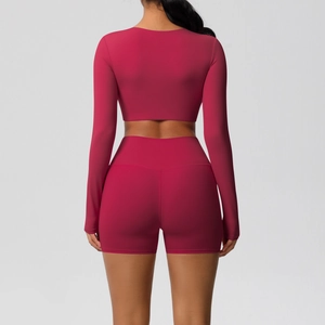 Achteraanzicht van donkerroze yoga-set met cropped top met lange mouwen en korte broek