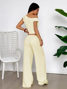 Detailed back side view of beige one-shoulder top and pleated wide-leg trousers set