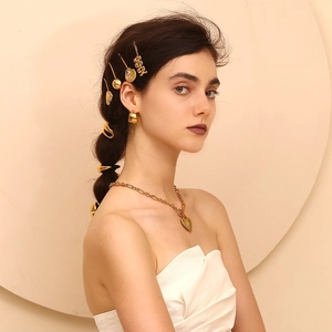 Close-up of a female model wearing 18K gold-plated shell hair clip and heart necklace