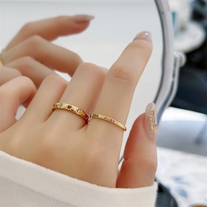 Detail van 18k vergulde ring met stergravure en slanke regenboog zirkoon stapelringen