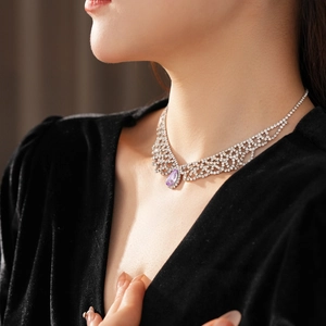 Dettaglio della collana a maglia diamantata con goccia viola indossata da modella