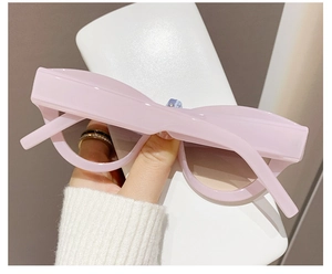 Close-up of pink cat eye sunglasses with thick retro frames and UV protection