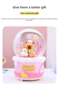 Close-up of pink Capybara snow globe with glowing base and cute character inside