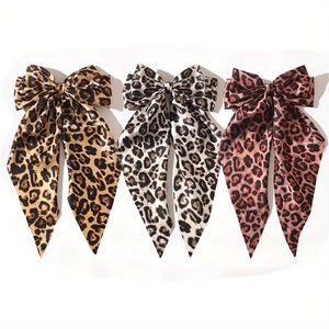 Elegant leopard print bow hair clips with long ribbons in brown, cream, and pink satin