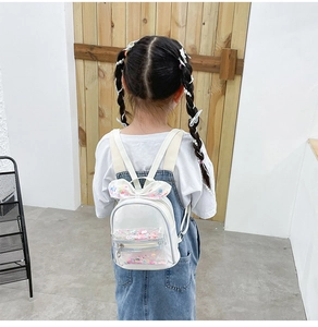 Detail view of cute girl wearing a white bow backpack with colorful sequins and sparkles