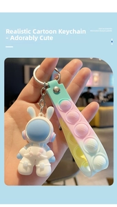 Detail of space rabbit astronaut keychain with colorful silicone pop-it hand strap