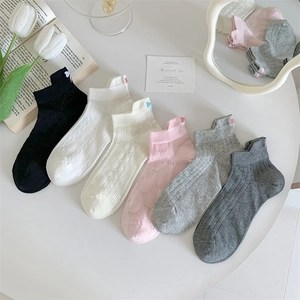 Flat lay of cotton boat socks with bow jacquard and heart embroidery in pastel colors