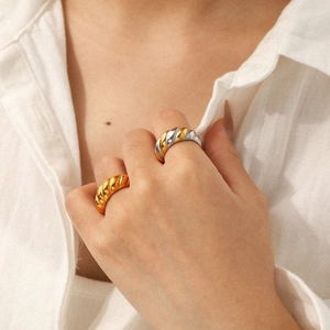 Polished stainless steel croissant ring set in gold and two-tone finishes on model