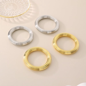 Lot de quatre bracelets joncs en acier inoxydable plaqué or 18 carats et argent rayés