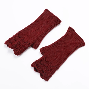 Detail view of dark red knit fingerless gloves with scale texture on white background