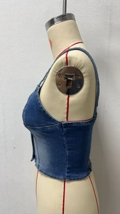Side view of blue washed denim corset top with tailored waist and metallic buttons on mannequin