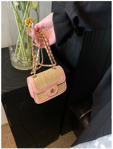 Close-up of pink leather edge and beige woven texture with gold flower clasp