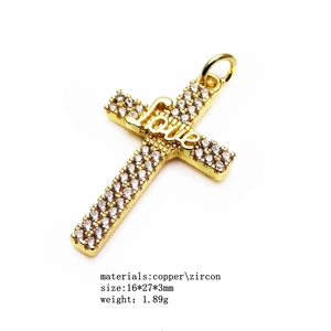Détail du pendentif croix plaqué or 14K avec incrustation de zircon et gravure Love