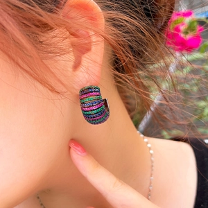 Close-up of model wearing C-shaped earrings with colorful pave zircon stones