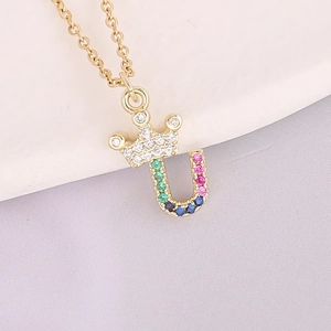 Macro view of crown letter U pendant with 18K gold plating and colorful zircons
