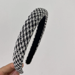 Close-up of black and white houndstooth fabric texture on a padded headband accessory