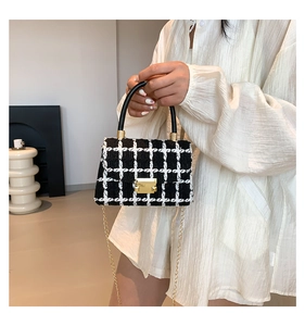 Détail du sac à carreaux en tweed avec fermoir doré et poignée noire