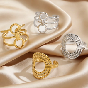 Macro shot of geometric gold and silver rings on silk background with textured surface
