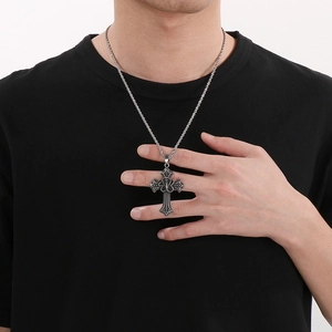 Gothic cross pendant with snake texture on silver chain worn by a male model