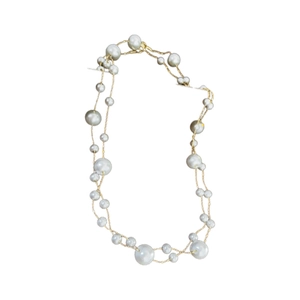 Double-layered gold plated necklace with white pearls on a clean white background