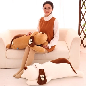 Soft plush sleeping puppy dogs in brown and white colors shown in a cozy home setting